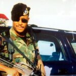 Clyburn in Fully geared Uniform Standing by a Car